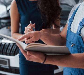 Your signature please woman auto salon with employee blue uniform taking her repaired car back 360x320